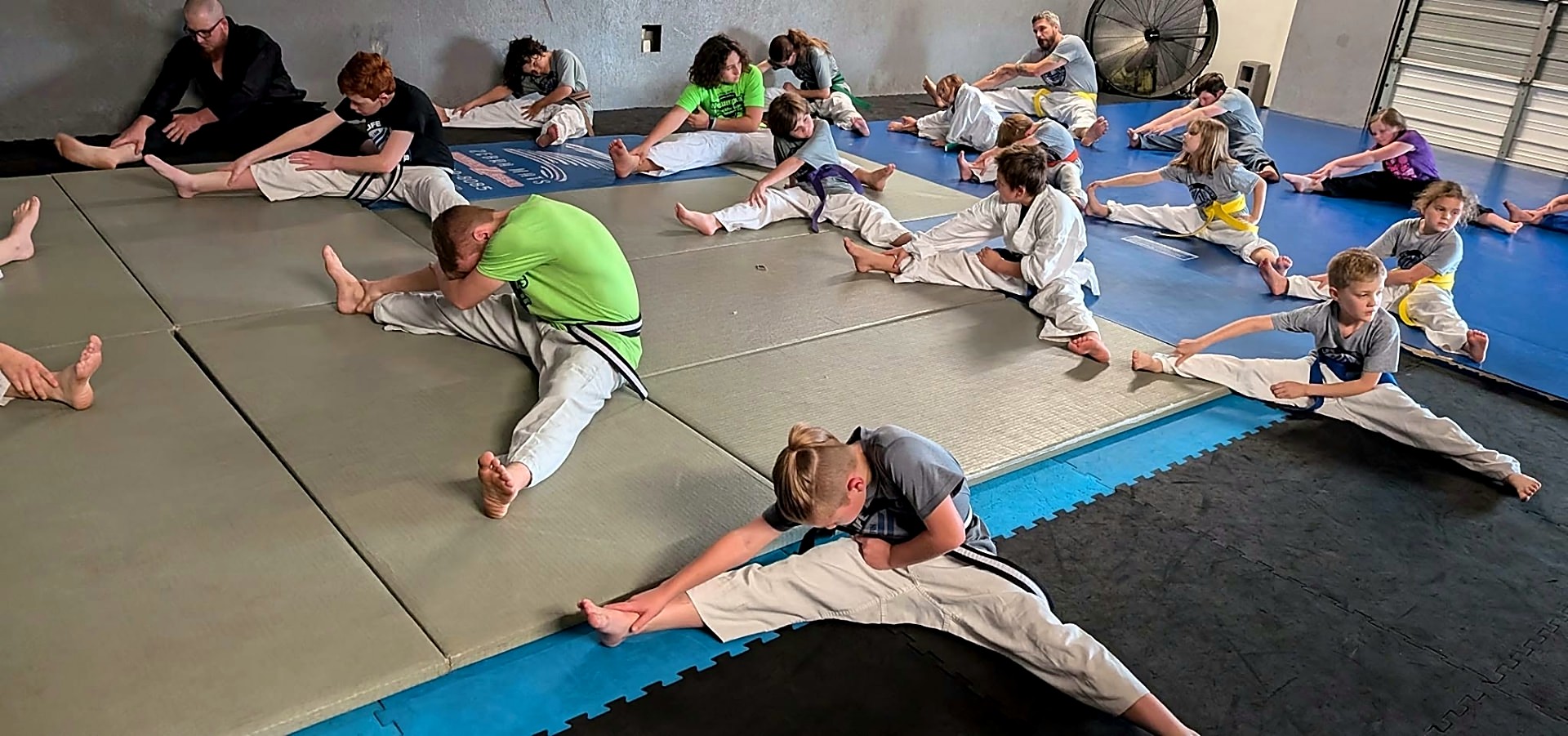 Taekwondo class stretching together on the mats